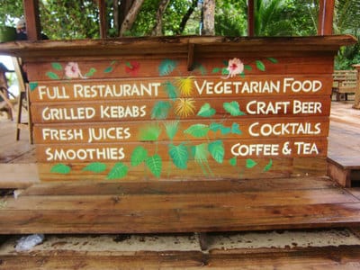 Hand painted lettering with tropical flowers and plants on beach in Bocas del Toro. 